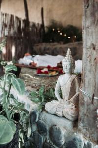 a statue of aitating woman sitting on a stone ledge at AguaMar Vichayito in Los Órganos