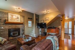 a living room with a couch and a fireplace at Nature's Getaway Mountain Resort- Cozy Bear Cabin in Nordegg