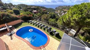 ein Swimmingpool in einem Hof mit Stühlen und Bäumen in der Unterkunft Luxury Villa Marina in Lloret de Mar