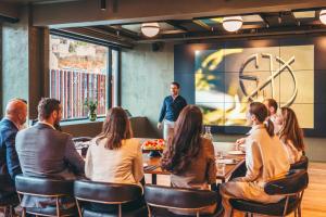 a group of people sitting around a table in a restaurant at Magic Hotel & Apartments Kl&oslash;verhuset in Bergen