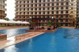 a large swimming pool in front of a building at L L I Condotel in Lapu Lapu City