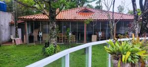 a house with a white fence in front of it at Casa de praia Guarau in Peruíbe