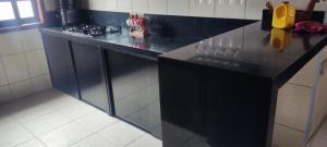 a kitchen with a black counter top in a room at Casa de praia Guarau in Peruíbe