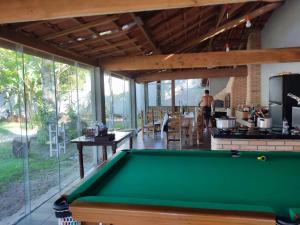 a pool table in the middle of a room with windows at Casa de praia Guarau in Peruíbe