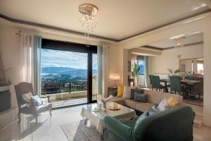 een woonkamer met een bank en een groot raam bij Villa Marena with extraordinary views in Agios Nikolaos