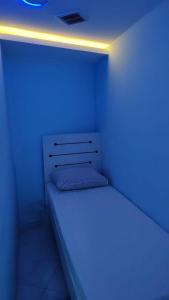 a room with a bed with a blue light on it at Al Khaleez Accommodation in Dubai
