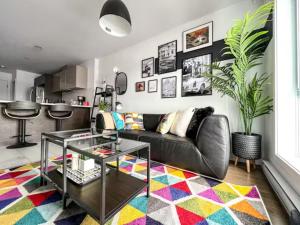 Mila Suites في مونتريال: غرفة معيشة مع أريكة سوداء وسجادة ملونة