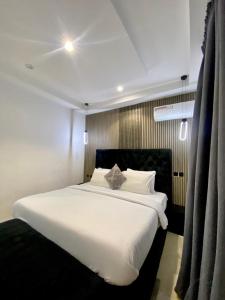 a bedroom with a large white bed with white pillows at De Fivez in Lagos