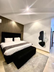 a bedroom with a large bed and a guitar on the wall at De Fivez in Lagos