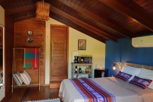 a bedroom with a large bed with blue walls at Pacha - Bangalôs em Pipa in Pipa
