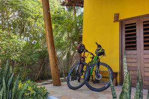 a bike parked next to a yellow house at Pacha - Bangalôs em Pipa in Pipa