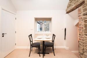 a dining room with a table and chairs and a window at Bankers Quarters - Apt 1 in Chapel en le Frith