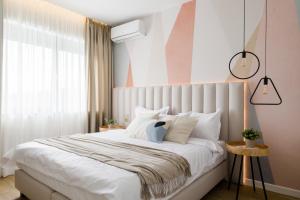 een slaapkamer met een groot wit bed met witte kussens bij Villa The Frame in Comarnic
