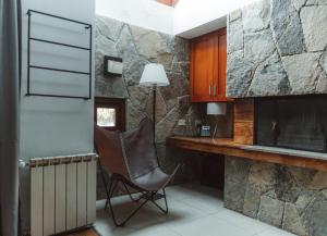 a chair in a kitchen with a stone wall at Cabañas Bosque del Nahuel in San Carlos de Bariloche