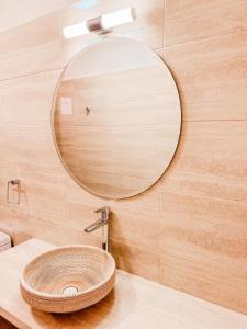 a bathroom with a round mirror and a sink at Hotel La Casona del Desierto in Huasco