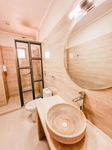 a bathroom with a sink and a toilet and a mirror at Hotel La Casona del Desierto in Huasco