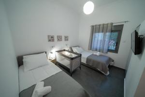 a small room with two beds and a window at Seaside House in Nea Makri in Nea Makri