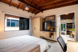 a bedroom with a bed and a flat screen tv at Level Coliving in Medellín
