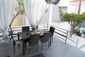 a black dining table and chairs on a patio at Seaside House in Nea Makri in Nea Makri