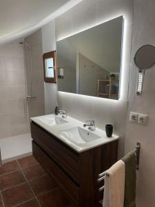 La salle de bains est pourvue d'un lavabo et d'un grand miroir. dans l'établissement Casas Demi verhuurhuis en appartement, à Vélez-Blanco