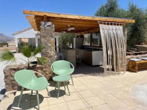 d'une terrasse avec 2 chaises vertes et une pergola en bois. dans l'établissement Casas Demi verhuurhuis en appartement, à Vélez-Blanco