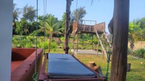 a tree house with a bed and a swing at Villa Pumziko in Kizimkazi