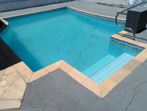 a swimming pool with a chair in it at Mi Casa, Águas de São Pedro in Águas de São Pedro