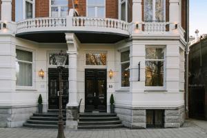 een wit huis met een zwarte deur en een balkon bij Sonder Park House in Amsterdam