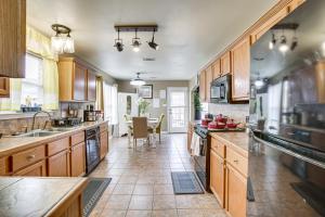 a large kitchen with wooden cabinets and a table at Spacious Family-Friendly Home in Denham Springs! in Denham Springs