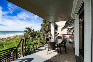 - un balcon avec une table et des chaises et la plage dans l'établissement The Beach Front, à Holmes Beach
