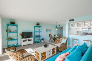 ein Wohnzimmer mit einem blauen Sofa und Stühlen in der Unterkunft Sunset Terrace 104 in Bradenton Beach