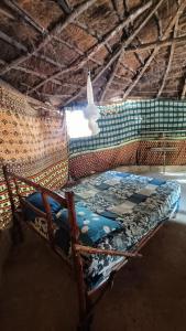 Bett in einem Zimmer mit Fenster in der Unterkunft Campement Kaymba Lodge in Kachiouane