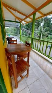 eine Veranda mit einem Holztisch und Stühlen in der Unterkunft Cool & Calm Hotel in Manzanillo