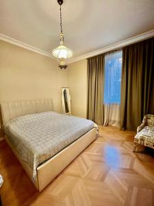 um quarto com uma cama e uma grande janela em Old Tbilisi em Tbilisi