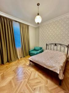 um quarto com uma cama e uma cadeira verde em Old Tbilisi em Tbilisi