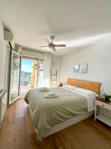 a white bedroom with a large bed and a window at Apartamento Benicàssim Sunset Calm&Views in Benicàssim