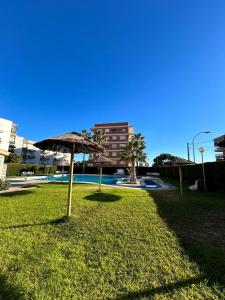 a grassy area with an umbrella in a park at Apartamento Benicàssim Sunset Calm&Views in Benicàssim