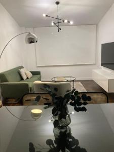 Apartamento elegante céntrico في فيغو: غرفة معيشة مع أريكة خضراء وطاولة