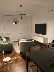 Apartamento elegante céntrico في فيغو: غرفة معيشة مع أريكة وتلفزيون