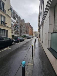 una strada vuota con auto parcheggiate sul lato di un edificio di French Luxury Paris a Parigi