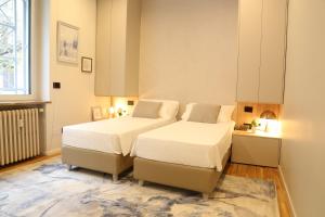 a bedroom with two beds and a large window at Meyland suites centro in Milan