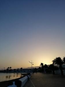 puesta de sol sobre una playa con palmeras y agua en Casa Noray 18 en Playa Honda