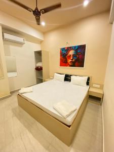 Schlafzimmer mit einem Bett mit Wandgemälde in der Unterkunft Golden Lotus Varanasi in Varanasi