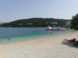 a group of people in the water at a beach at Apartman Ružica in Pučišća