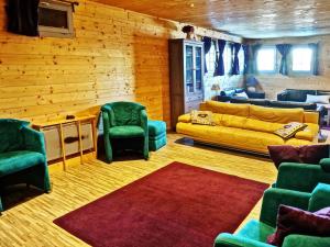 a living room with a yellow couch and green chairs at Chalet Le Corbier, 8 pièces, 16 personnes - FR-1-267-257 in Villarembert