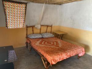 ein Schlafzimmer mit einem Bett in einem Zimmer in der Unterkunft Campement Kaymba Lodge in Kachiouane