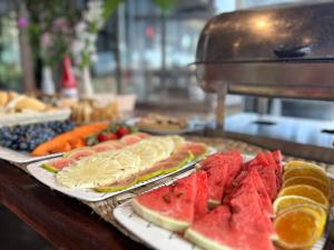 um buffet com frutas e legumes em pratos numa mesa em Pousada Solar de Búzios em Búzios