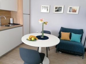a small kitchen with a white table and a blue chair at Apartman Ružica in Pučišća