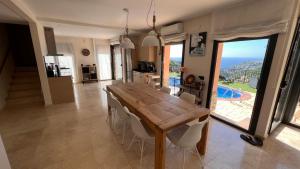 cocina y comedor con mesa de madera y sillas en Villa Marina, en Lloret de Mar