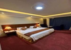 a hotel room with a large bed and two tables at فندق نسيم أبها in Abha